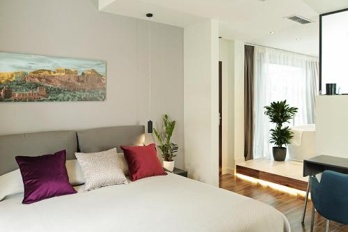 a bedroom with a bed with purple and white pillows at The Gem Society Hotel in Athens