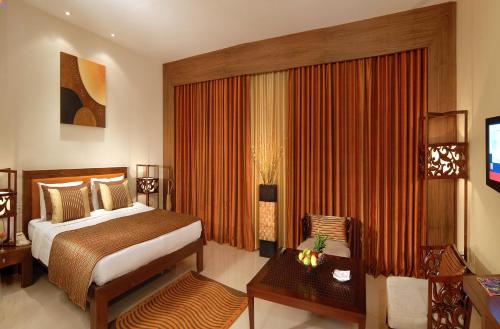 a hotel room with a bed and a television at The Manohar Hyderabad in Hyderabad