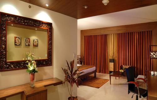 a living room with a mirror and a bedroom at The Manohar Hyderabad in Hyderabad