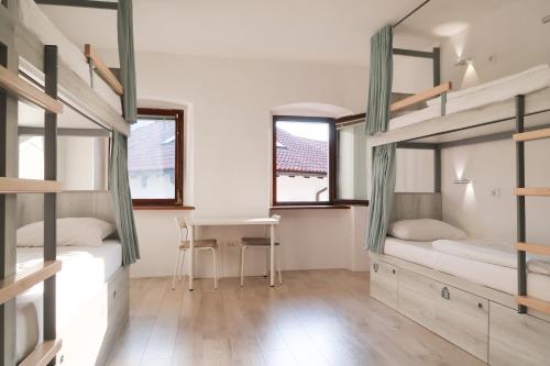 a room with two bunk beds and a table at Premium Hostel Kobarid in Kobarid