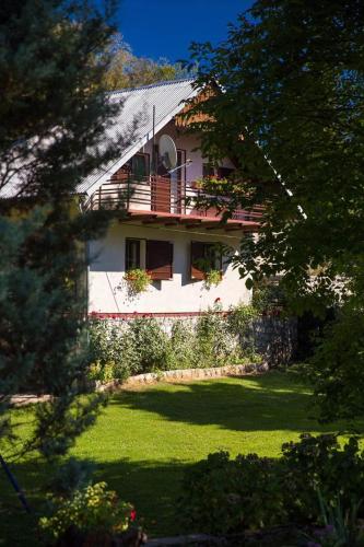 a white house with a balcony and a yard at Lukovo in Lukovo