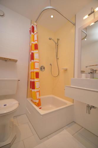a bathroom with a shower and a sink and a toilet at Appartementhaus Alpenrose in Wallgau