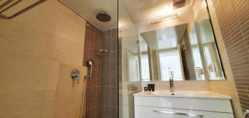 a bathroom with a shower and a sink and a mirror at BnBIsrael apartments - Ramat Yam Marine in Herzelia 