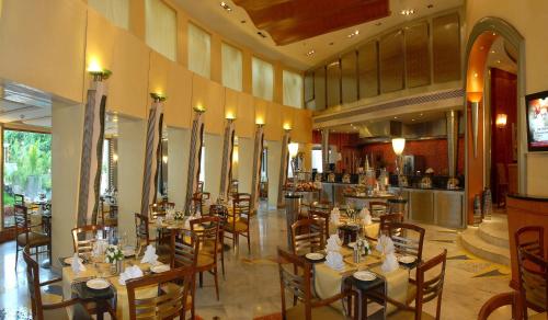 a restaurant with tables and chairs in a room at The Manohar Hyderabad in Hyderabad