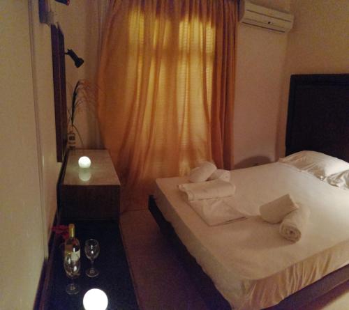 Una habitación de hotel con una cama con toallas. en Verdelis Inn en Ancient Epidavros