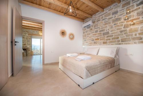 a bedroom with a bed and a stone wall at Irene Komos Independent House in Pitsidia