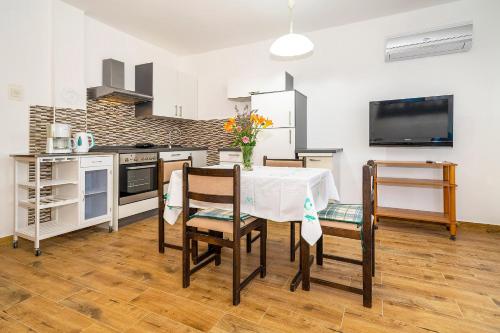 a kitchen and dining room with a table and chairs at Apartments Jurina in Krk
