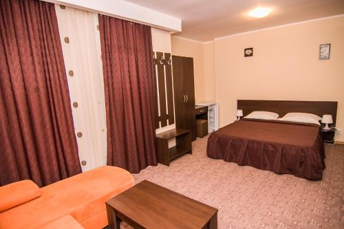 una habitación de hotel con una cama y un sofá en Vila KM 0, en Neptun