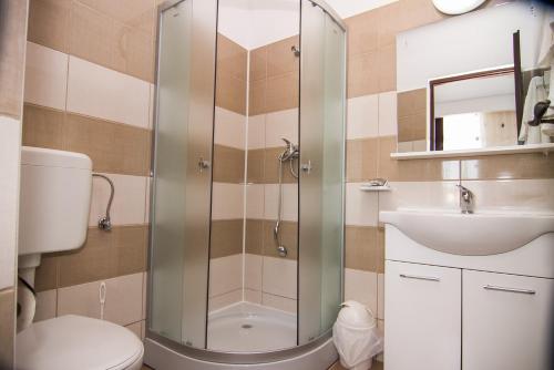 Un baño con ducha, inodoro y lavabo. en Vila KM 0, en Neptun