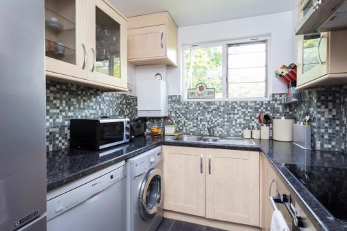 a kitchen with a sink and a dishwasher at Superhost's Amazing Spacious Flat with Great Links in London