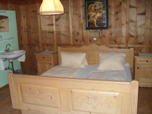 ペットイ・アム・アールベルクにあるHaus Schellenschmiedのシンク付きの客室の木製ベッド1台