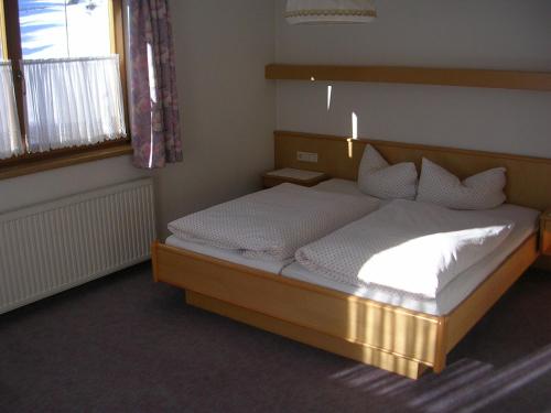 カウナータールにあるHaus Hafeleのベッドルーム1室(大型ベッド1台、白いシーツ、枕付)