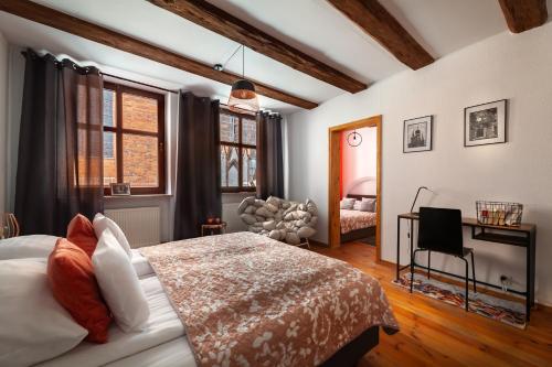 托倫的住宿－Kamienica Pod Piernikiem，一间卧室配有一张床、一把椅子和窗户。