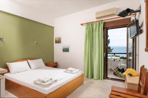 a bedroom with a bed and a window with a view at Fantasia Studios and Apartments in Neos Marmaras