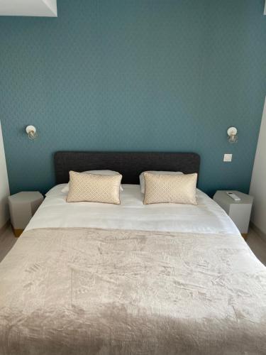 a bedroom with a large bed with two pillows at La Terrasse du Faubourg in Beaune