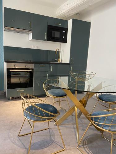 une cuisine avec une table en verre et quatre chaises dans l'établissement La Terrasse du Faubourg, à Beaune