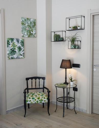 a chair and a table with a lamp and plants on the wall at S'Ilixi in Quartucciu