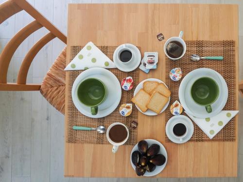 a table with cups of coffee and bread on it at S'Ilixi in Quartucciu