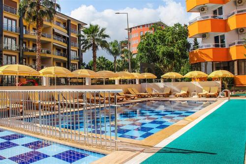 a swimming pool with umbrellas and chairs and a hotel at Yaman Life Hotel in Alanya