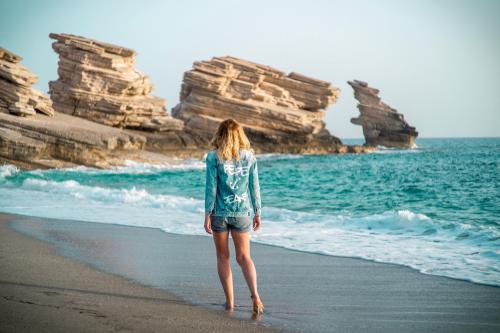 a woman walking on the beach looking at the ocean at Villa Thalassa in Triopetra