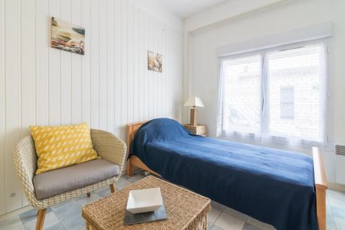 une chambre avec un lit, une chaise et une fenêtre dans l'établissement ile de Nole, à Rochefort