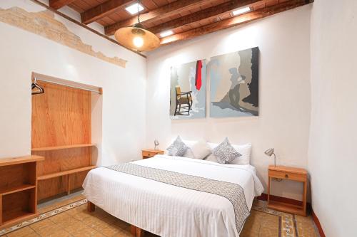 a bedroom with a large white bed in a room at Hotel Meson Cuevano in Guanajuato