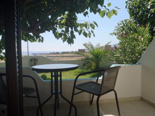 a table and chairs on a balcony with a view at Orthi Ammos in Frangokastello