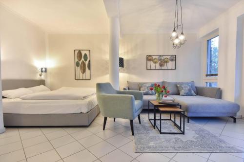 1 dormitorio con cama, sofá y mesa en Villa Marfa Wohnung 5 en Heringsdorf