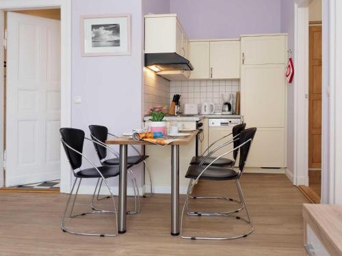 cocina con mesa y sillas negras en Villa Lucie Else 06, en Heringsdorf