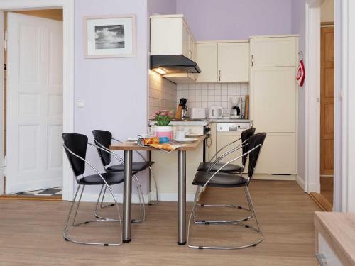 a kitchen with a table and black chairs at Villa Lucie Else 06 in Heringsdorf
