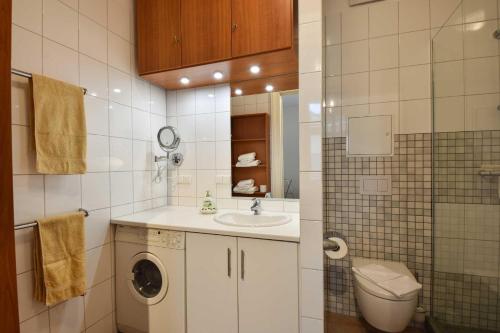 uma casa de banho com uma máquina de lavar roupa e um lavatório em Villa Medici Wohnung 6 em Heringsdorf