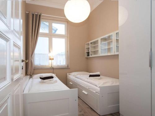ヘリングスドルフにあるVilla Lucie Else 02 - Steuerbordのベッド2台と窓が備わる小さな客室です。