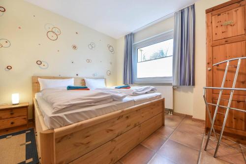 um quarto com uma cama com uma moldura de madeira e uma janela em Haus Dünenweg 01 em Heringsdorf