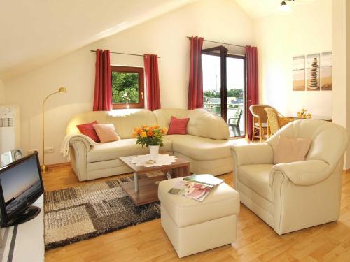 a living room with two white couches and a tv at Haus auf der Höhe - Panorama in Heringsdorf