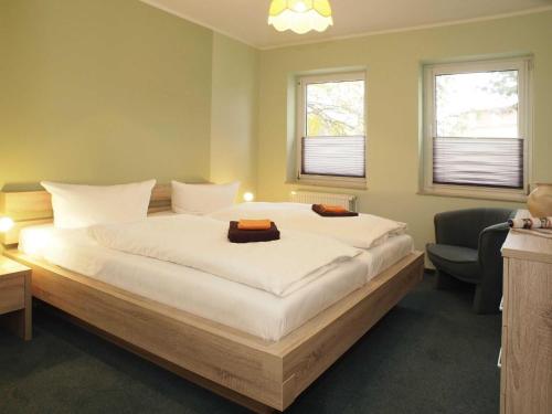 una camera da letto con un grande letto bianco e due finestre di Wohnung am Schloonsee B4 a Heringsdorf
