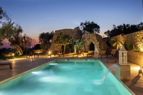 a swimming pool in front of a stone building at Il Torrino B&B in Sannicola
