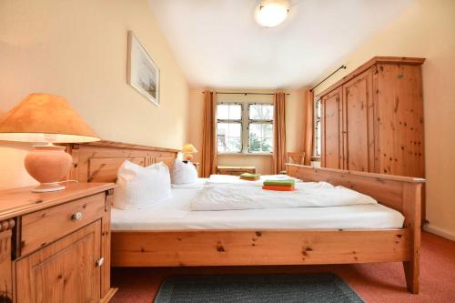 ヘリングスドルフにあるOstseepark Captain`s Haus 1 3のベッドルーム1室(ランプ付きの木製ベッド1台付)