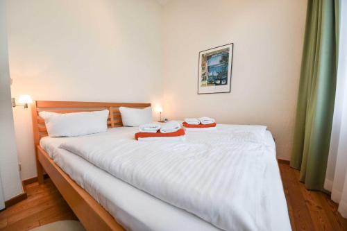 ein Schlafzimmer mit einem großen weißen Bett mit zwei Handtüchern darauf in der Unterkunft (14b) Villa Emmy 02 in Heringsdorf