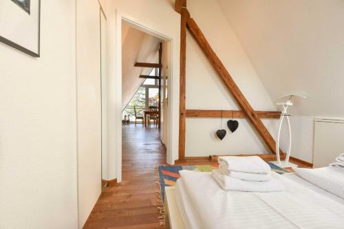Cette chambre comprend un lit avec des draps blancs et un couloir. dans l'établissement Villa Emmy Wohnung 9, à Heringsdorf