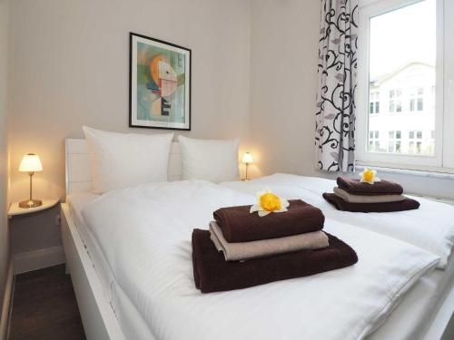 ヘリングスドルフにあるVilla Lucie Else 01の白いベッド(タオル付)が備わります。