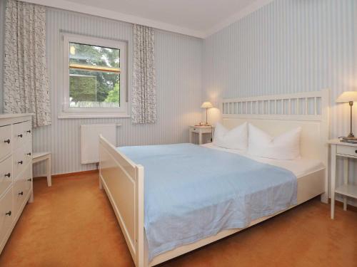 um quarto com uma grande cama branca e uma janela em Inselhaus Heringsdorf EG em Heringsdorf