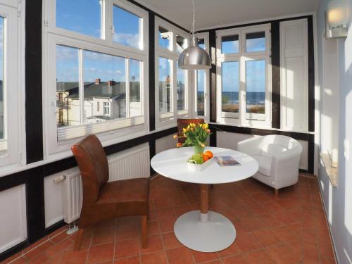 アールベックにあるVilla Vineta Wohnung 206のテーブルと椅子、窓が備わる客室です。