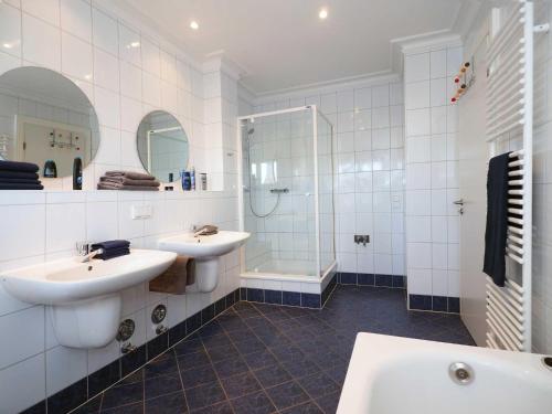 a white bathroom with two sinks and a shower at Villa Vineta Wohnung 206 in Ahlbeck