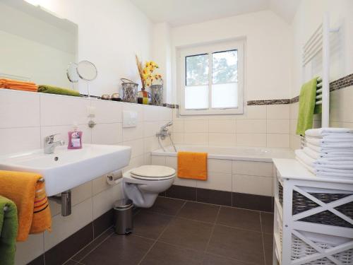 La salle de bains est pourvue d'un lavabo, de toilettes et d'une baignoire. dans l'établissement Ferienhaus Birgit, à Korswandt