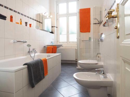 a bathroom with a sink and a toilet and a tub at Villa Elisabeth Wohnung Welle in Heringsdorf