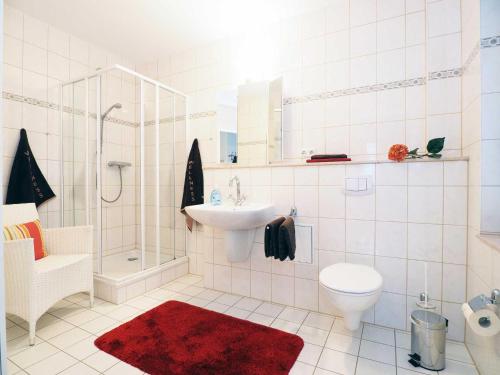 Baño blanco con lavabo y aseo en Haus Meerblick Wohnung 7, en Ahlbeck