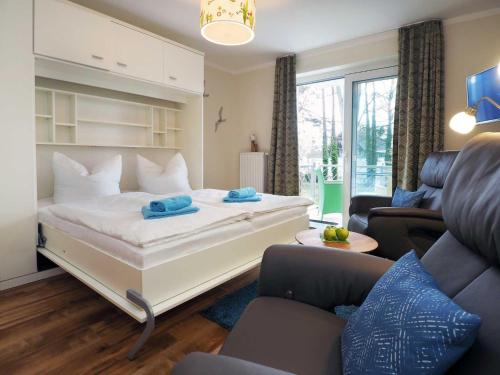 een slaapkamer met een groot bed en een woonkamer bij Villa Strandperle 17 in Bansin