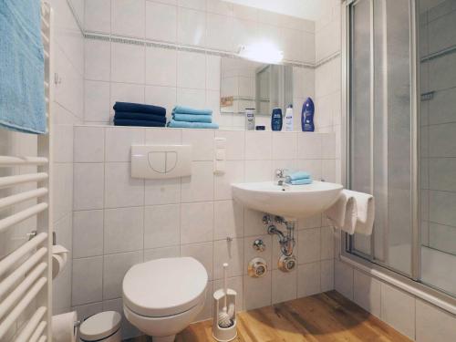 een witte badkamer met een toilet en een wastafel bij Villa Strandperle 17 in Bansin