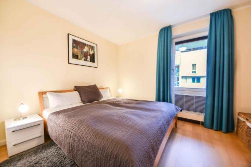 Schlafzimmer mit einem Bett und einem Fenster mit blauen Vorhängen in der Unterkunft Forum Marinar 20 in Heringsdorf