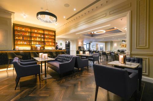 a restaurant with chairs and tables and a bar at Belvedere Hotel Parnell Square in Dublin